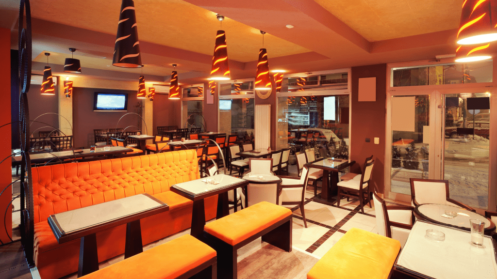 Social Media Marketing for Restaurants & Takeaways - A Complete Guide 5 Inside a restaurant with stunning cone-shaped lights with white tables and yellow sofas and chairs. Great for picture of customers that they can post on their social media accounts.