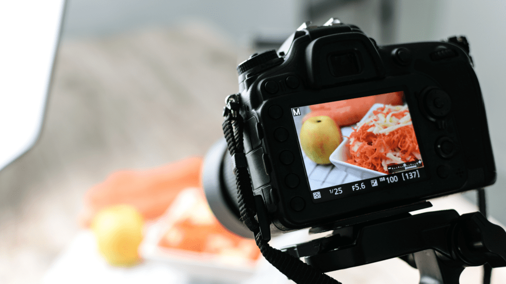 Social Media Marketing for Restaurants & Takeaways - A Complete Guide 3 DSLR camera snapping a photo of a salad and an apple. This way restaurant and takeaways get to update customers to help their social media marketing.