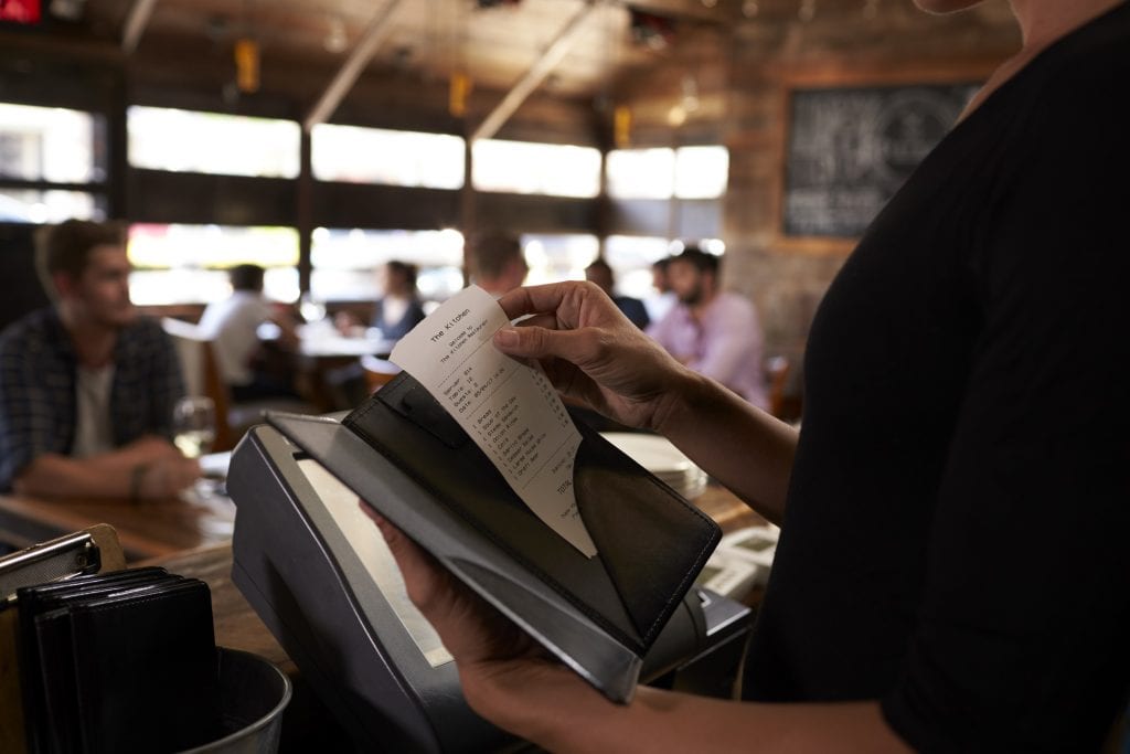 How to Calculate ROI in Marketing: The Complete Guide for Restaurant Technology ROI Calculator 2 preparing the bill at a restaurant to be taken to PQAHZS8
